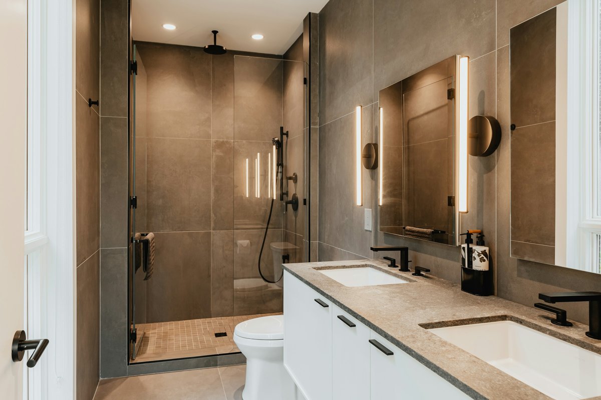 A bathroom with two sinks, a toilet and a shower