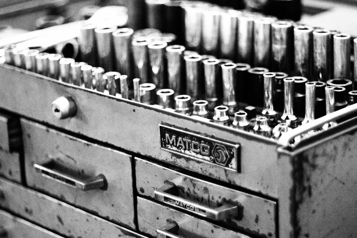 A metal tool box filled with lots of screws