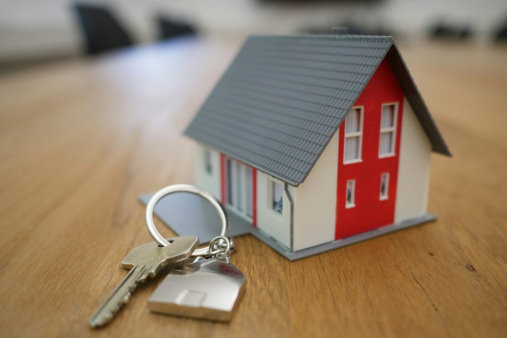 White and red wooden house miniature on brown table