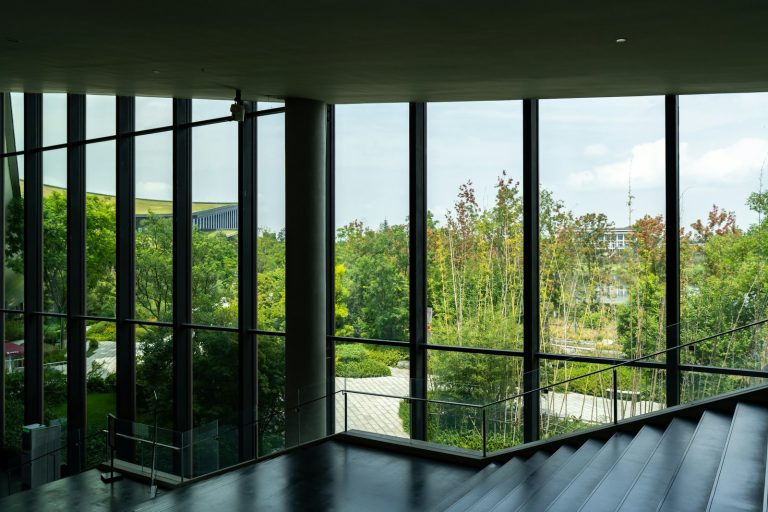 Modern interior with large windows overlooking green trees