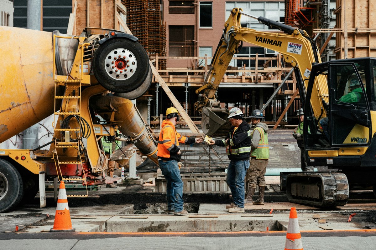 A couple of men standing next to a construction site