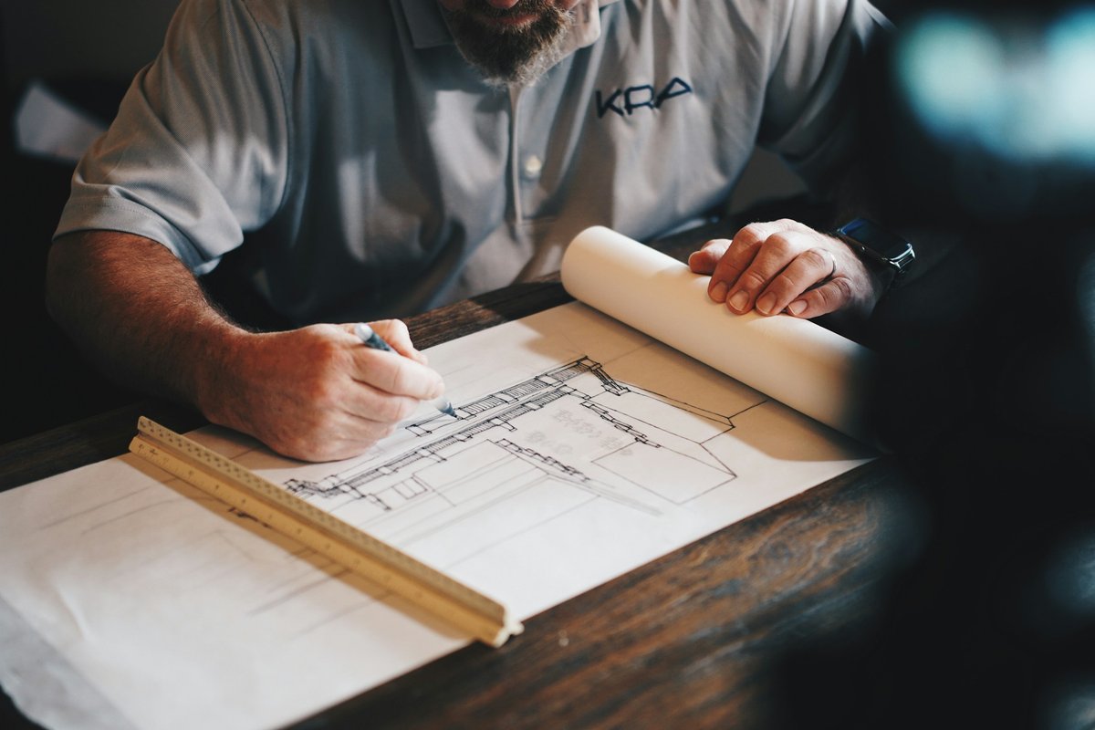 An architect working on a draft with a pencil and ruler