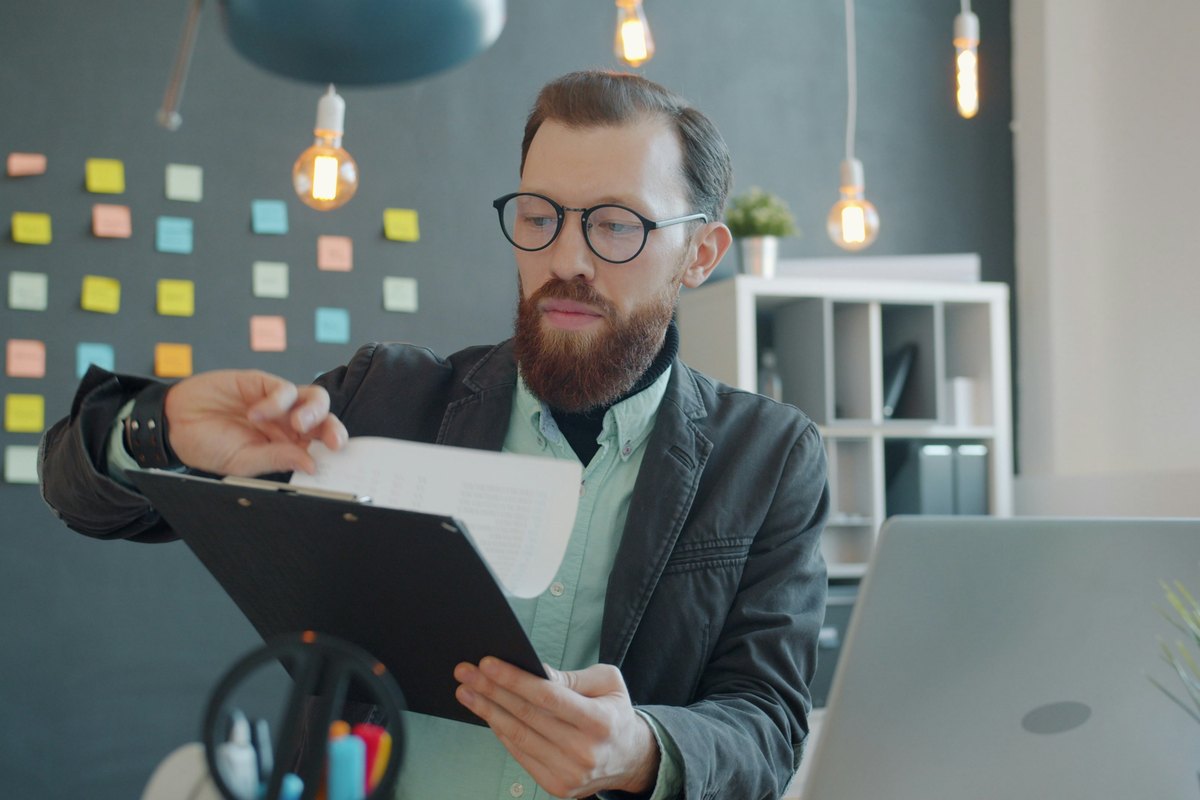 Man in glasses reviewing documents at desk