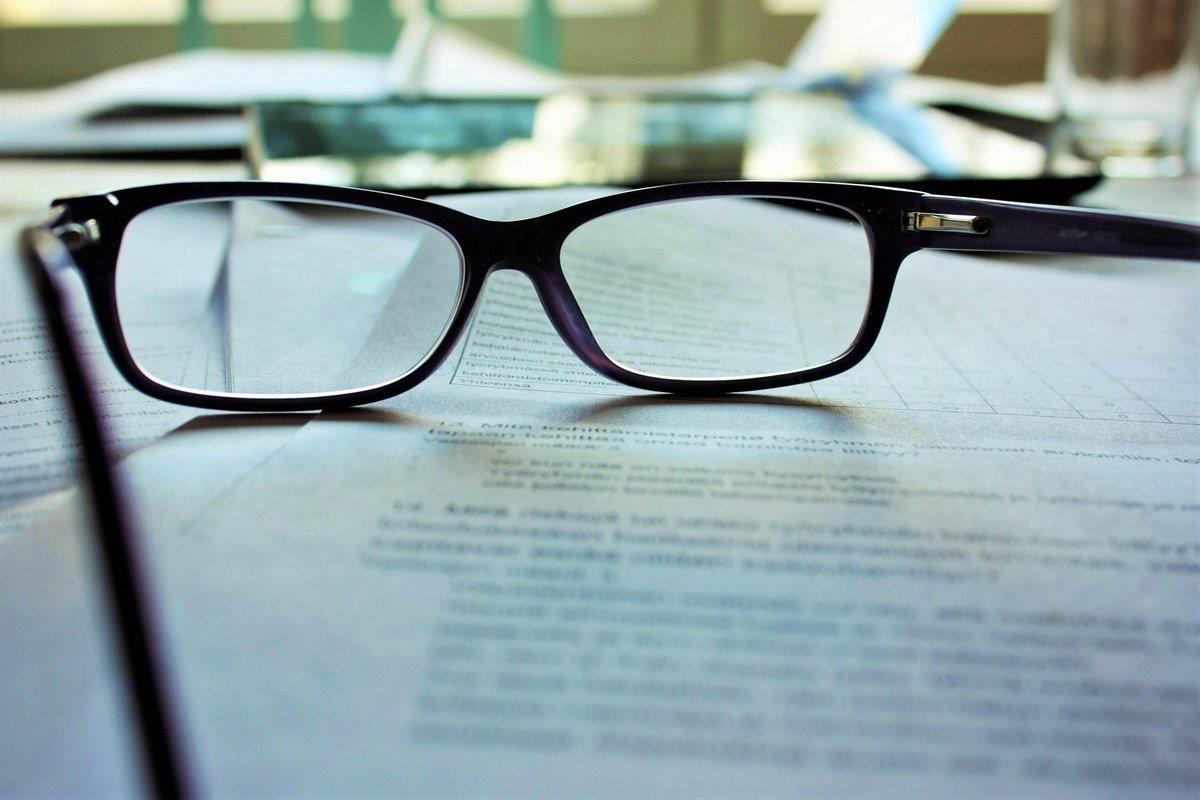 Black-framed eyeglasses on white printing paper