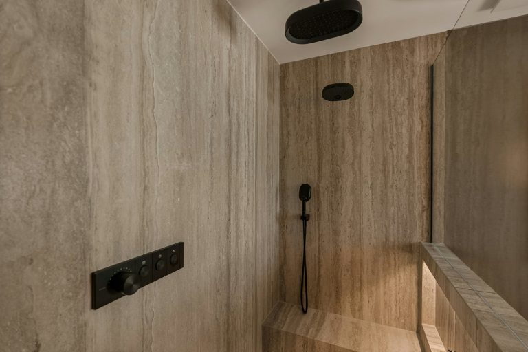 Modern bathroom with a walk-in shower and controls.