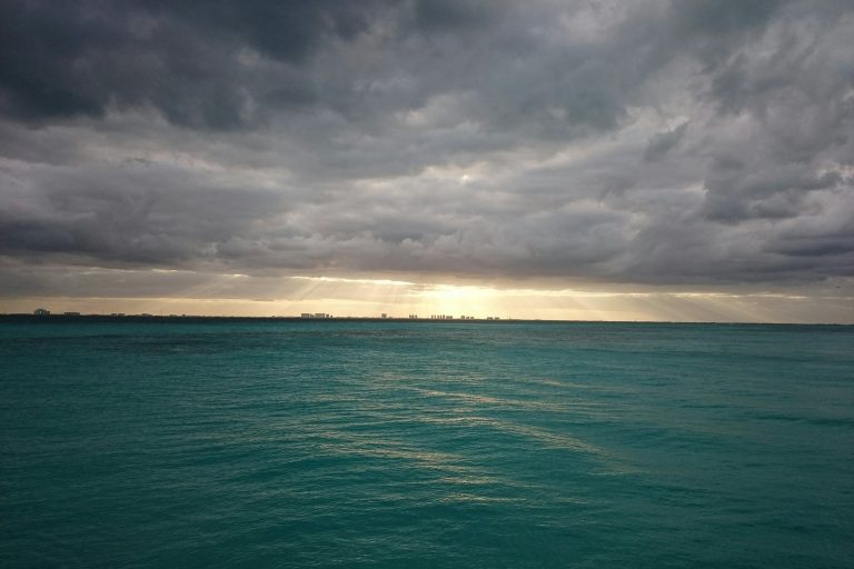 green body of water and white clouds