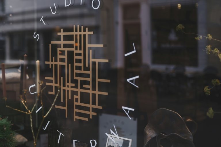 Studio logo on glass storefront with reflections