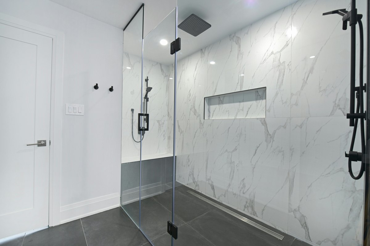 Modern bathroom with a frameless glass shower partition showing the clean, low-profile look that suits an office fit-out