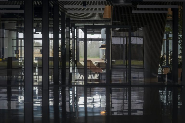 Modern office interior with glass walls and reflections