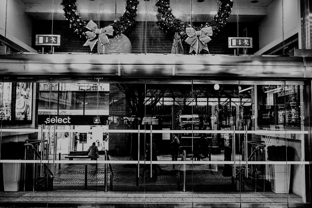 Storefront with holiday decorations and closed doors.