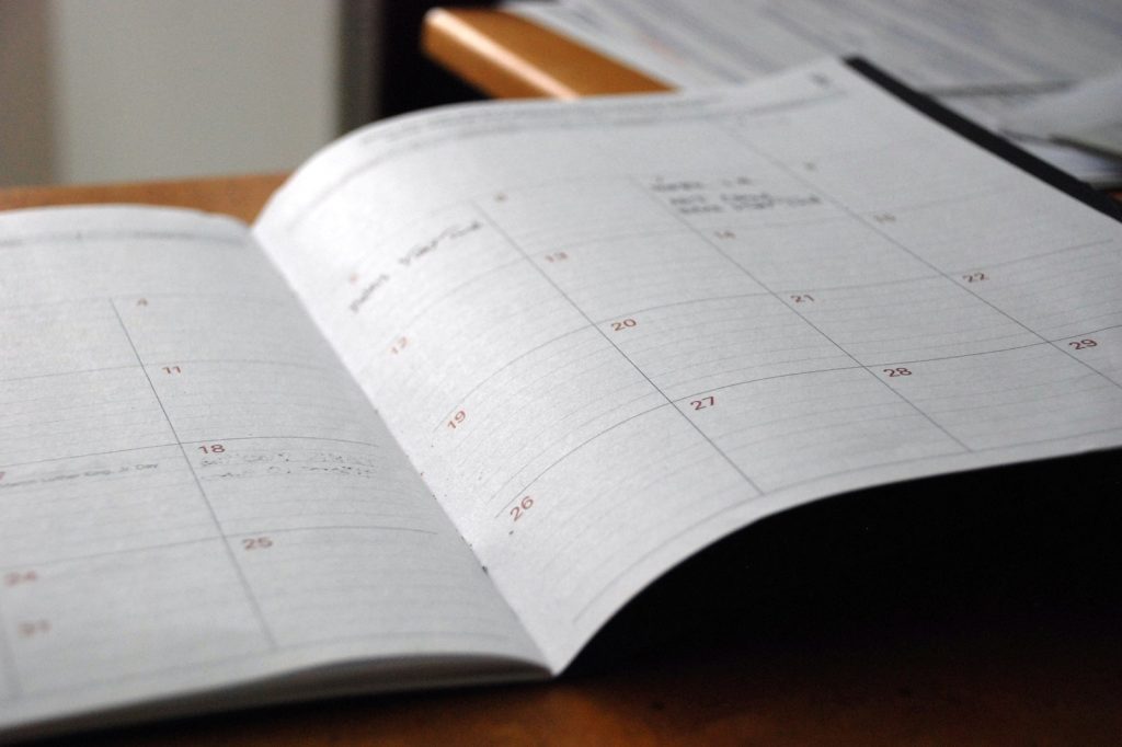 open monthly planner on wooden desk