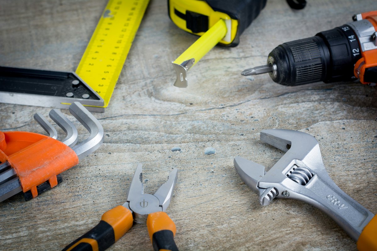A variety of maintenance tools on a workbench, showing the kind of routine attention that prevents most storefront failures