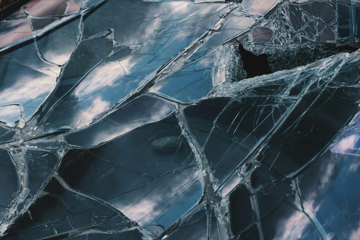 A close-up of a broken glass window, the predictable result of non-impact glass meeting hurricane debris