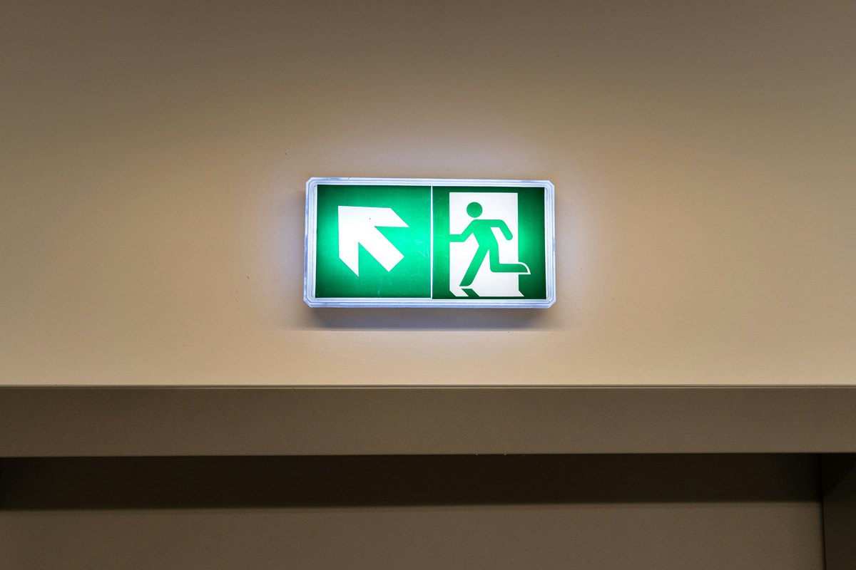 An illuminated emergency exit sign, showing the kind of egress signage required on commercial properties