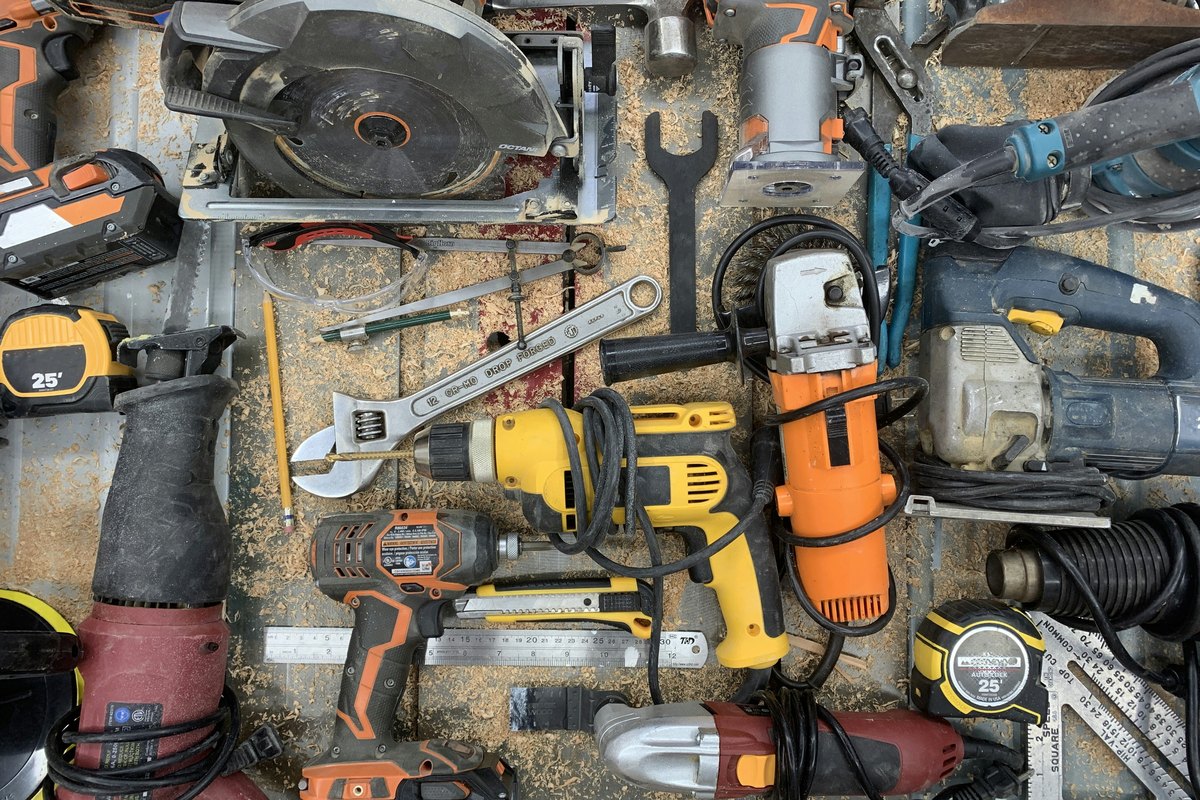 Power tools and equipment on a workbench, illustrating the kit a DIYer would bring to a storefront project